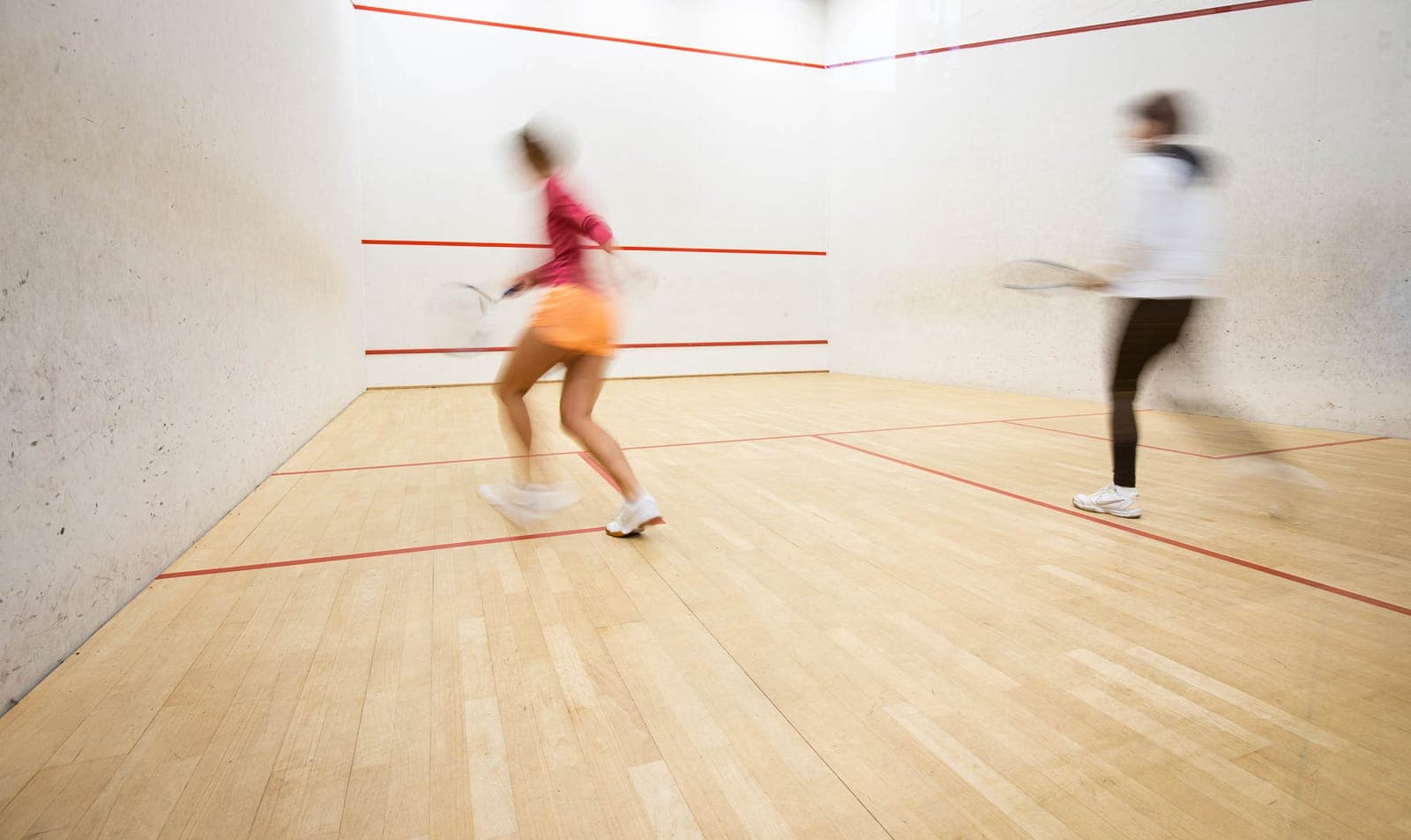 Squash players in action on court